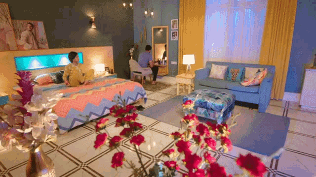 a man sits at a desk in a bedroom next to a bed