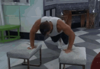 a man is doing push ups on ottomans in a living room .