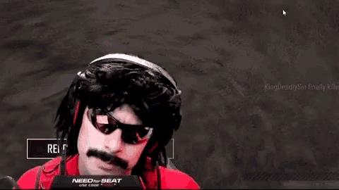 a man with a mustache and sunglasses is wearing headphones and a red shirt while playing a video game .