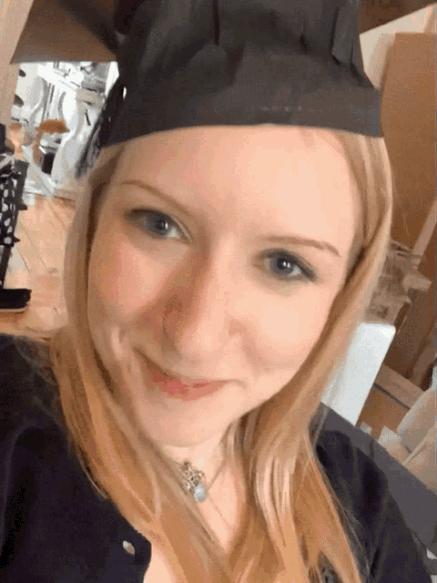 a woman wearing a black graduation cap and smiling