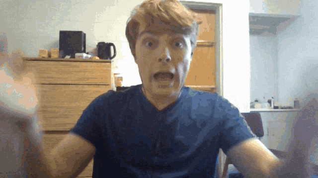 a man in a blue shirt with his mouth open
