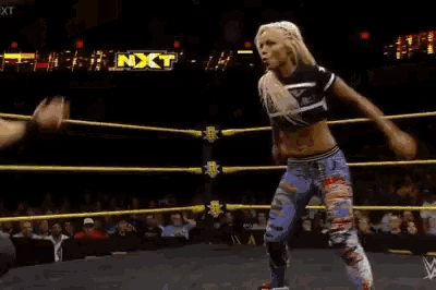 two women are wrestling in a ring with a sign that says nxt on it
