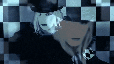 a woman in a top hat is standing next to a man in a suit