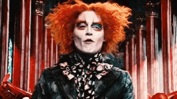 the mad hatter from alice in wonderland is wearing a black jacket and a scarf .