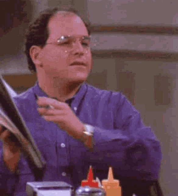 a man in a purple shirt is holding a sticker with a bitcoin sign on it .