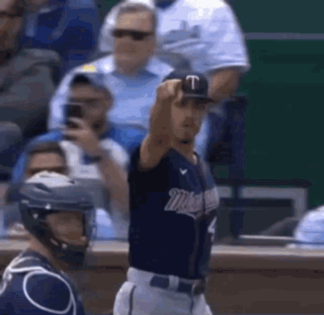 a baseball player wearing a minnesota uniform holds up his fist