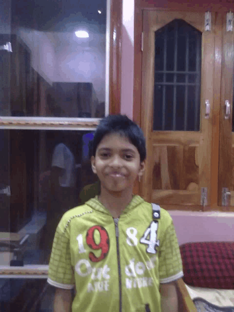 a boy wearing a green shirt with the number 19 on the front