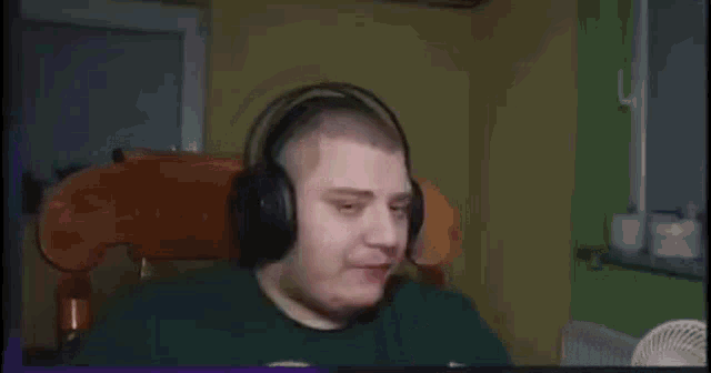 a man wearing headphones is eating a popsicle while sitting in a chair .