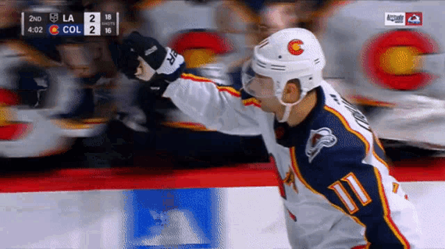 a hockey player with the number 11 on his jersey celebrates a goal