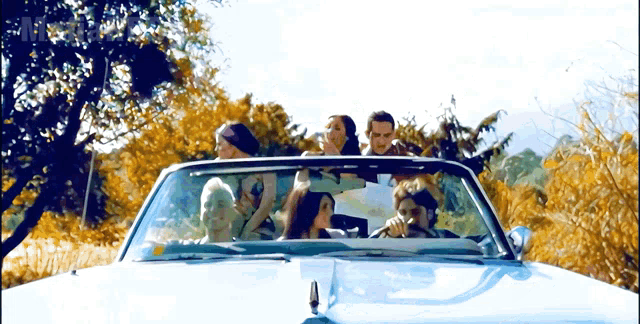 a group of people are riding in a convertible with the word mr. on the bottom