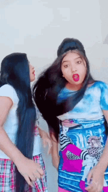 two girls with long hair are standing next to each other and one has a surprised look on her face