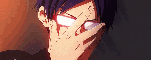 a close up of a person covering their eyes with their hands .