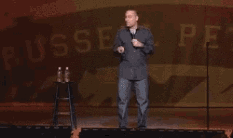 a man is holding a microphone and making a funny face while talking into it .
