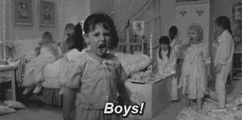 a black and white photo of a little girl screaming in a room with a group of children .