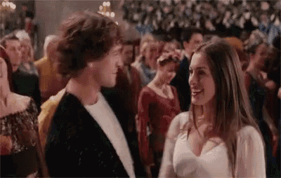 a man and a woman are standing next to each other in a crowded room .