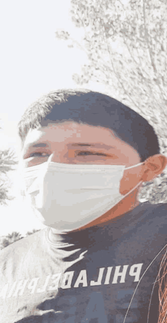 a young man wearing a face mask and a shirt that says ' what a journey ' on it