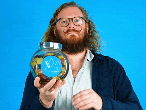 a man with a beard is holding a jar of gummy bears with a mountain on it