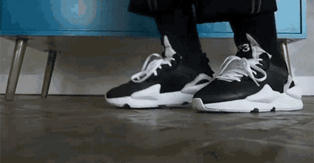 a person is wearing a pair of black and white sneakers with the number 3 on the side