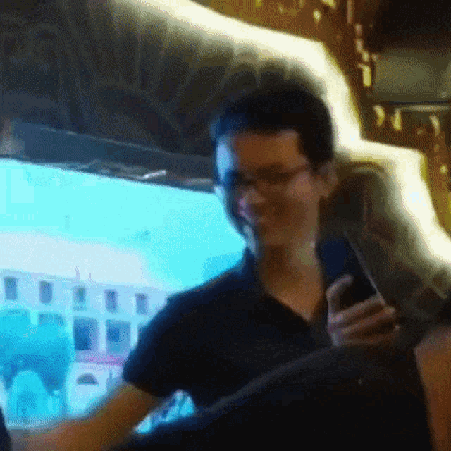 a man is smiling while looking at his phone