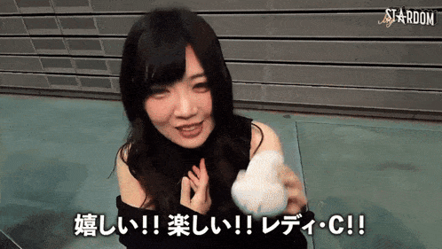 a woman is holding a white object in front of a sign that says stardom on it
