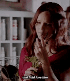 a woman with red hair is holding a plant and saying and i did love him