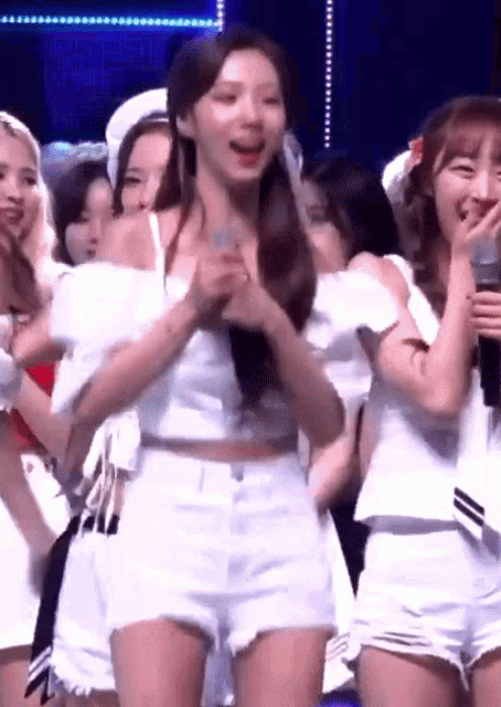 a group of young women are standing on a stage .