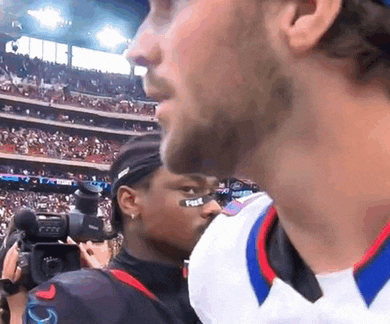 a man with a fox logo on his helmet stands in a crowded stadium