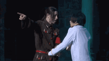 two men are standing next to each other on a stage .