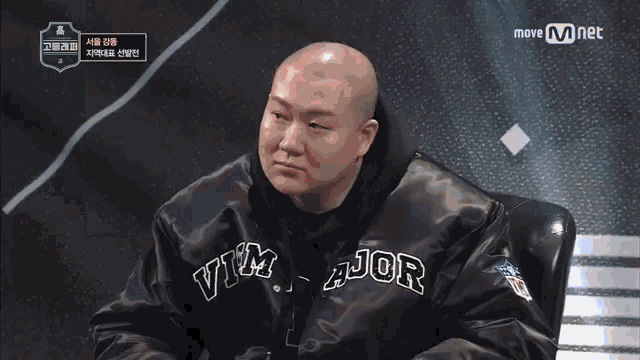 a bald man is wearing a black jacket with the word jor on it