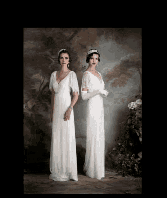two women in long white dresses are standing next to each other