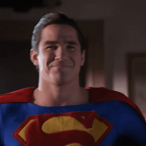 a man dressed in a superman costume is clapping his hands