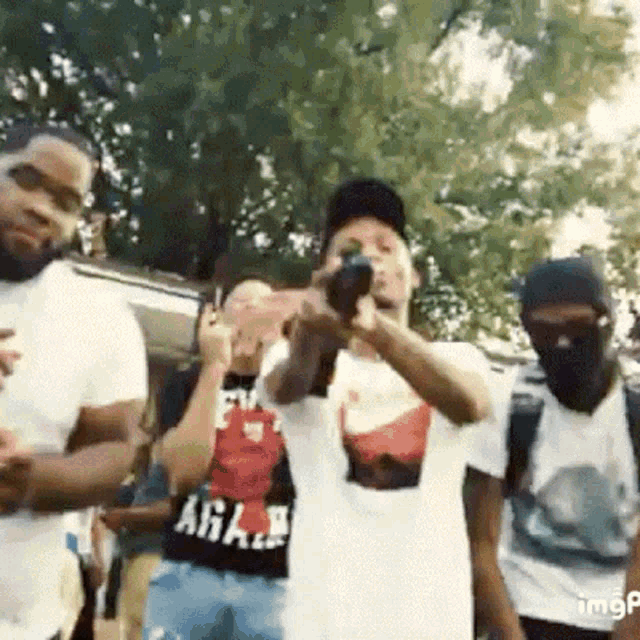 a group of men are standing next to each other and one of them is wearing a shirt that says a.g.a.