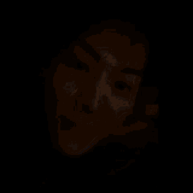 a close up of a person 's face in a dark room .