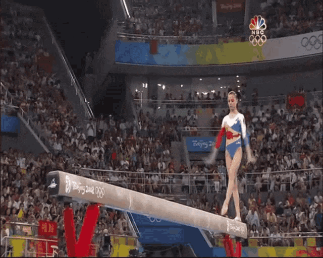 a female gymnast performs on a balance beam at the beijing olympics