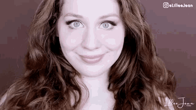 a close up of a woman 's face with curly hair and blue eyes .