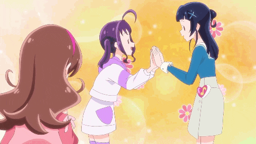 a girl with a heart on her skirt is giving a high five to two other girls