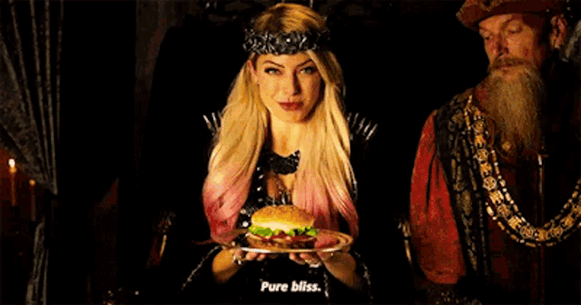 a woman with a crown on her head holds a plate of food and says pure bliss