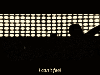 a man is standing in front of a crowd at a concert and saying `` i can 't feel '' .