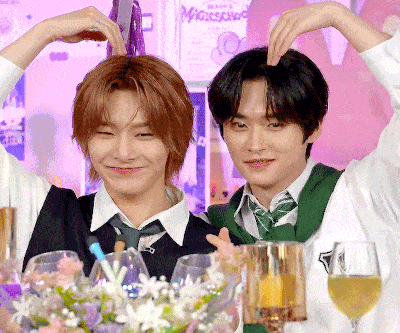 two boys are making a heart shape with their hands in front of a sign that says nightschool