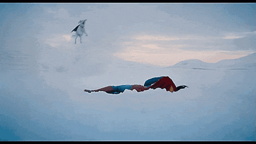 a close up of a man laying in the snow