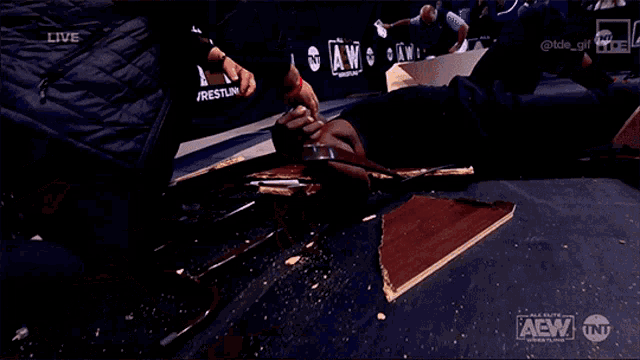 a man is laying on the ground in front of a aew wrestling logo