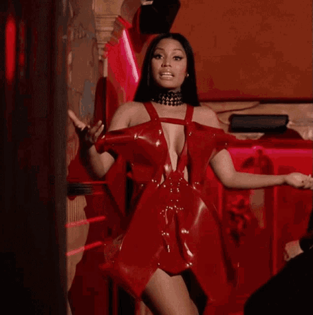 a woman in a red dress is giving a thumbs up sign