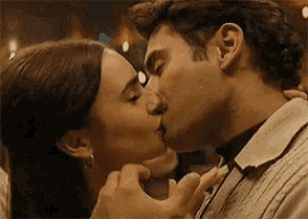a man and a woman are kissing each other in a dark room .