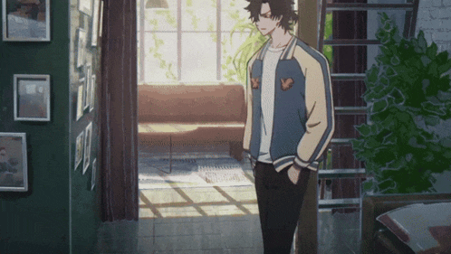 a man in a bomber jacket stands in a hallway
