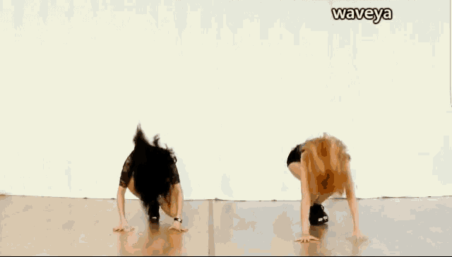 a woman with red hair is doing a handstand in front of a white wall with the word waveya above her