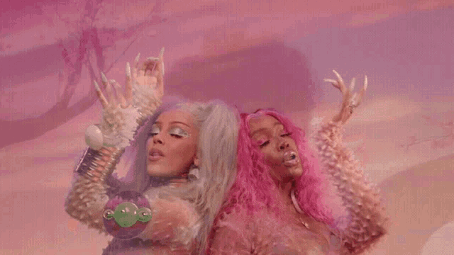 two women with pink hair and white hair are standing next to each other in front of a pink sky