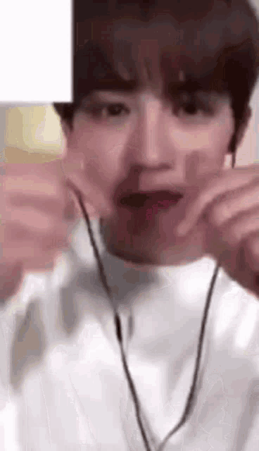 a young man wearing headphones is making a face .