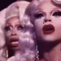 a close up of a drag queen 's face with red lips .