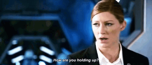 a woman in a suit and white shirt is talking to another woman and asking how are you holding up .