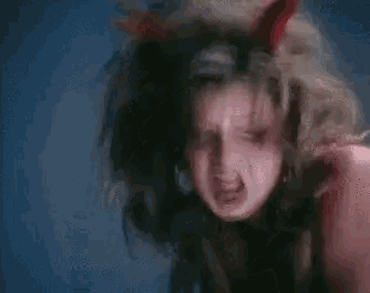 a woman is wearing devil horns on her head and making a funny face .
